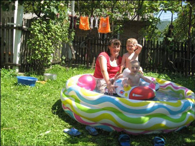 Росіянка Ганна Кочеткова купає сина Олексія та доньку Марію у надувному басейні.