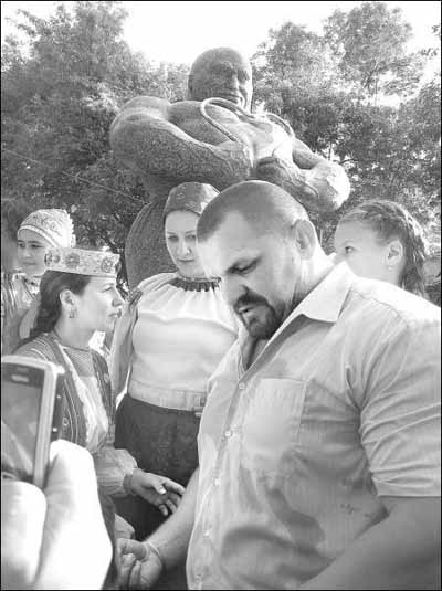 Важкоатлет Василь Вірастюк фотографується біля пам'ятника Івану Фірцаку у селі Білки на Закарпатті