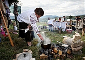 Жінка готує на вогнищі страву з картоплі під час фестивалю "Гуцульська ріпа"