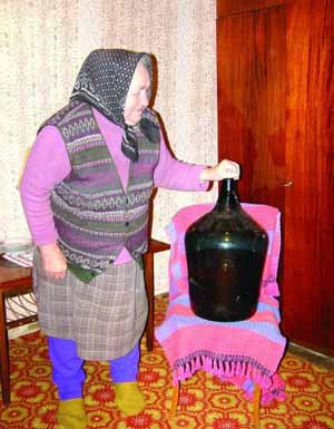 Марія Варга з села Арданово на Закарпатті показує 25-літрову пляшку горілки, яку вигнала 25 років тому