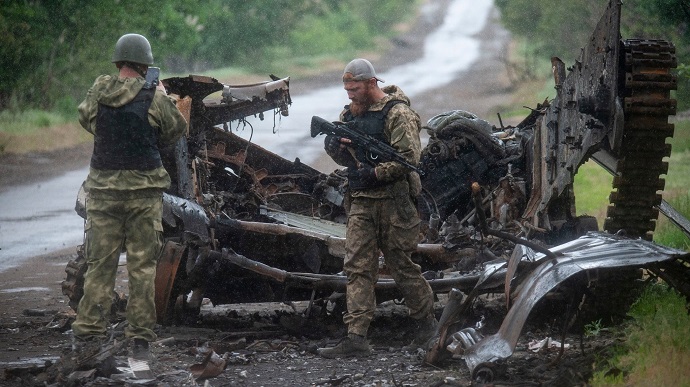 Українські військові біля розбитої техніки ворога